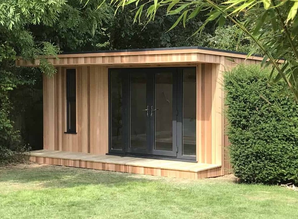 Beautiful Garden Room Ideas To Complement Any Garden Cedar clad garden room with a canopy, sitting in between bushes in well established garden