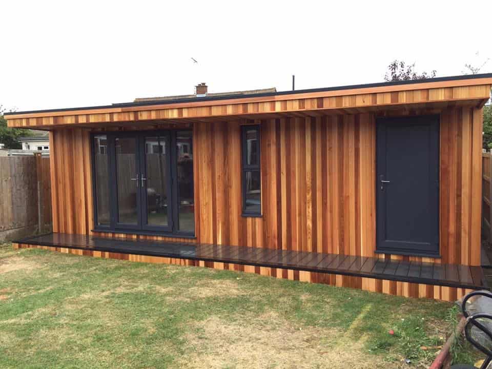 Cedar clad garden games room, sits snug at the bottom of a garden.